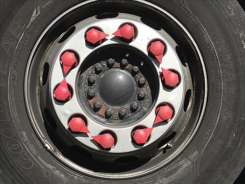 Red_loose_wheel_nut_indicators_arranged_point-to-point_on_a_Scania_lorry_wheel.jpg
